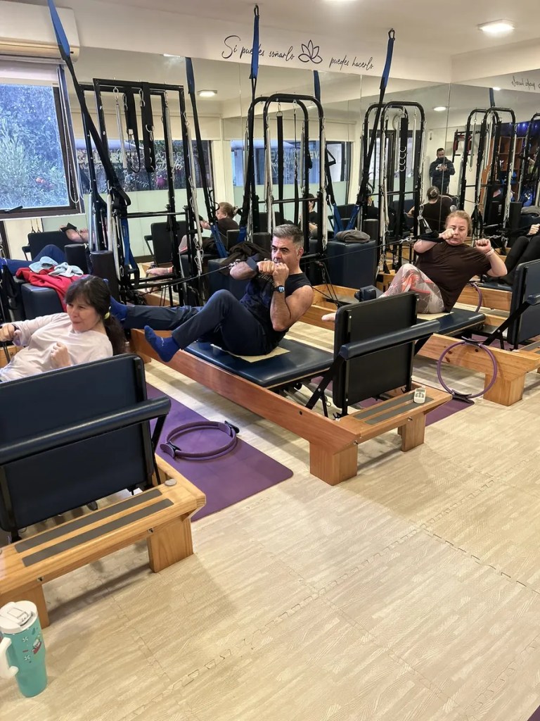 Alumnos realizando ejercicios de fuerza en una clase grupal de Pilates Reformer en Calvert Pilates Studio